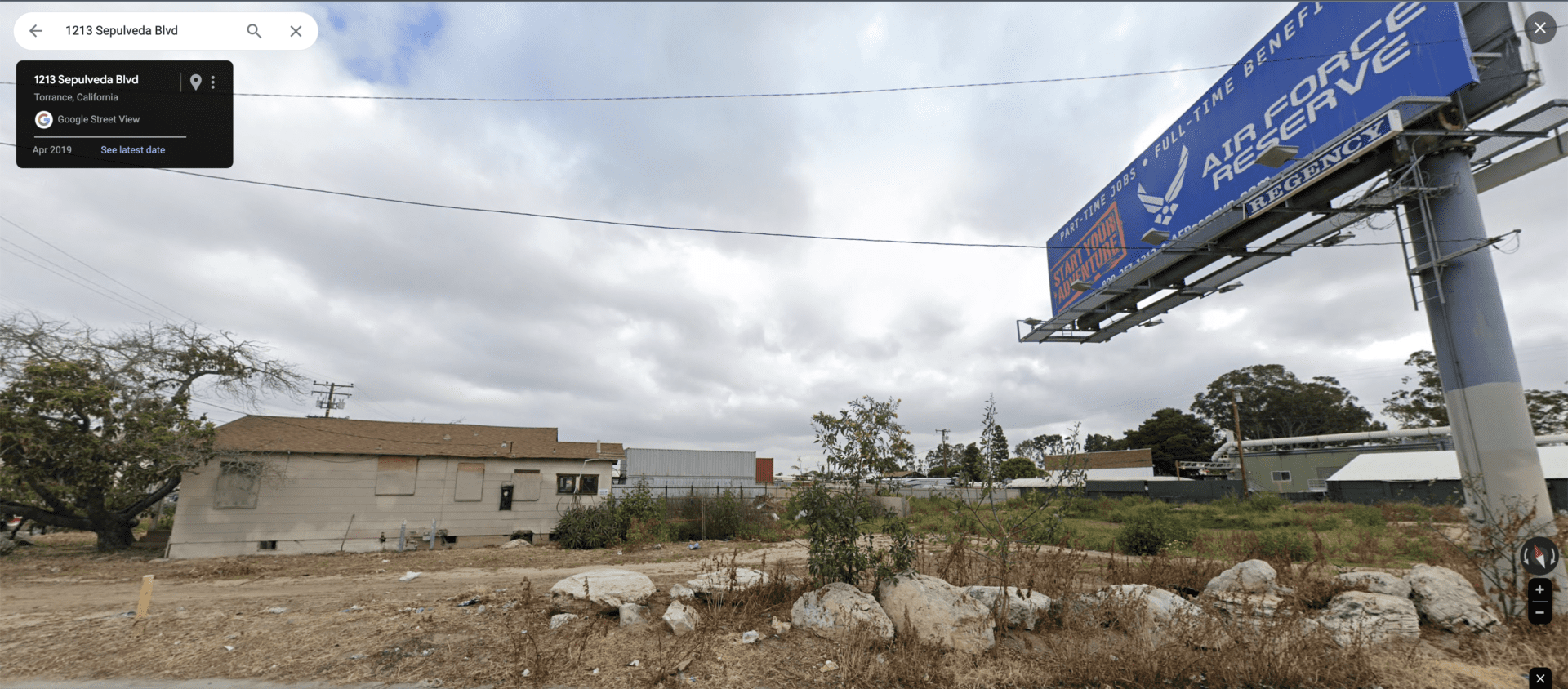 A view of a lot with a billboard on the side.