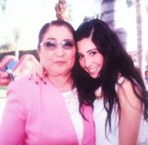 A woman and her daughter posing for the camera.